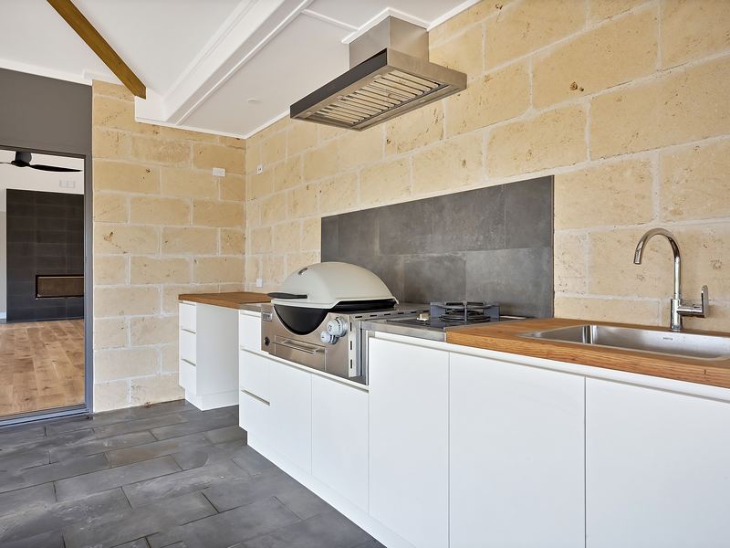 Outdoor kitchen with a built-in gas barbecue, cooktop and sink
